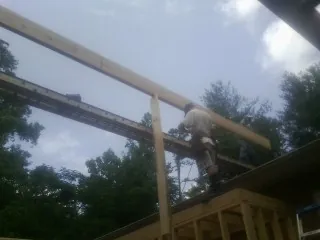 Carpenter setting a ridge beam over a new addition frame — Ice Dam Removal by Roofing Brothers in Pittstown