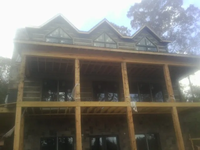 Dormers and porch framing on a large log home under construction — Roof Coating work by our crew in Pittstown
