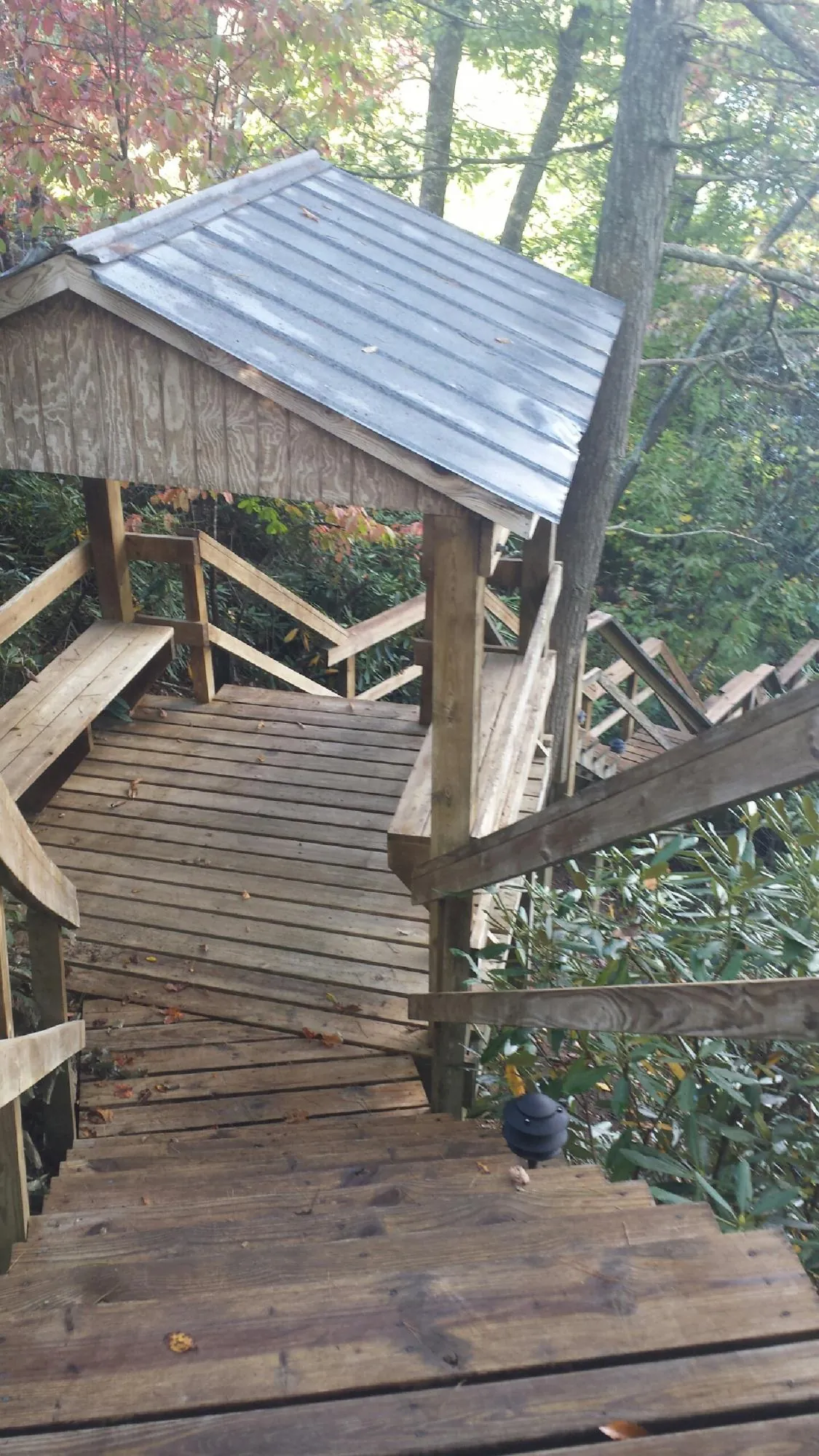 Metal roofed shelter over wooden steps on a wooded walkway — Skylight Repair & Installation work by our crew in Pittstown
