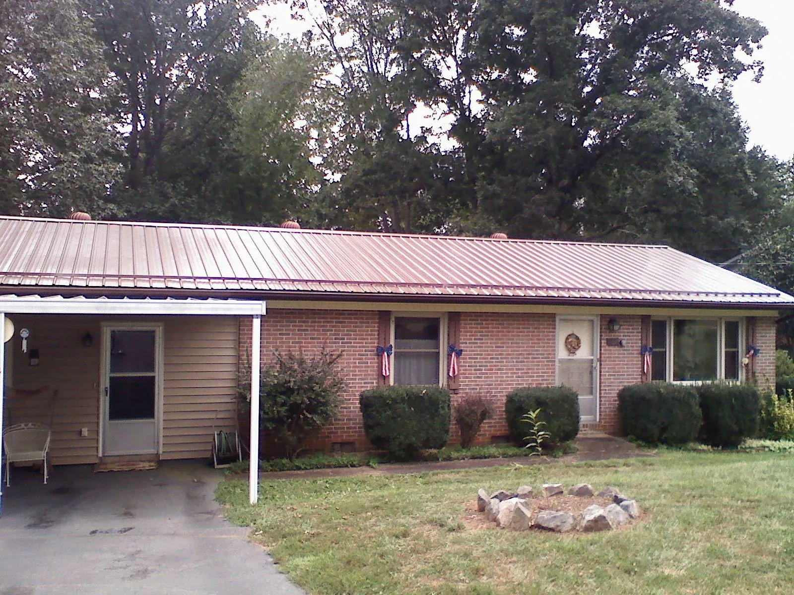 Bronze metal roof and carport on a brick ranch home — Roof Repair work by our crew in Pittstown