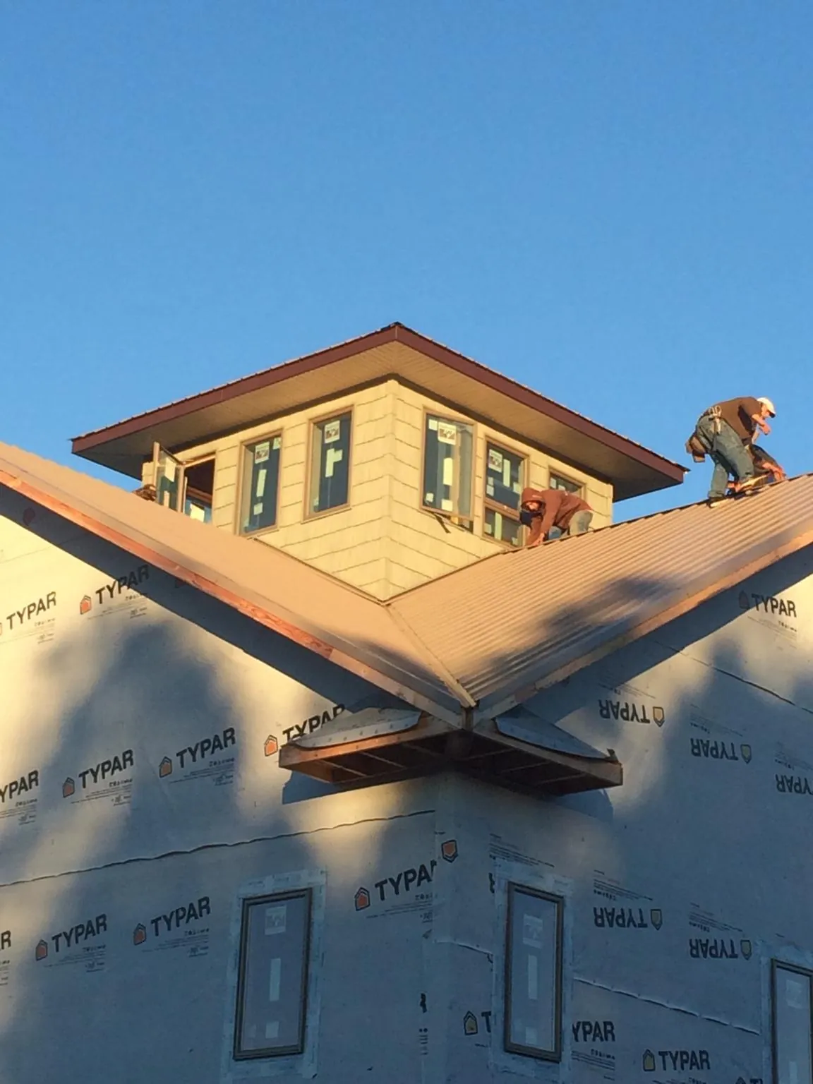 Roofers working around a rooftop cupola on a new metal roof at sunset — Roof Waterproofing in Pittstown by Roofing Brothers